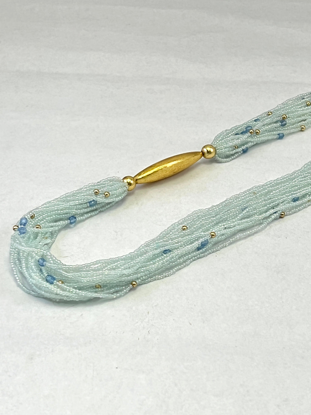 COLLIER MULTICOUCHE EN PERLES DE ROCAILLE JECKO DORÉES ET PERLES CRIS AVEC FIL