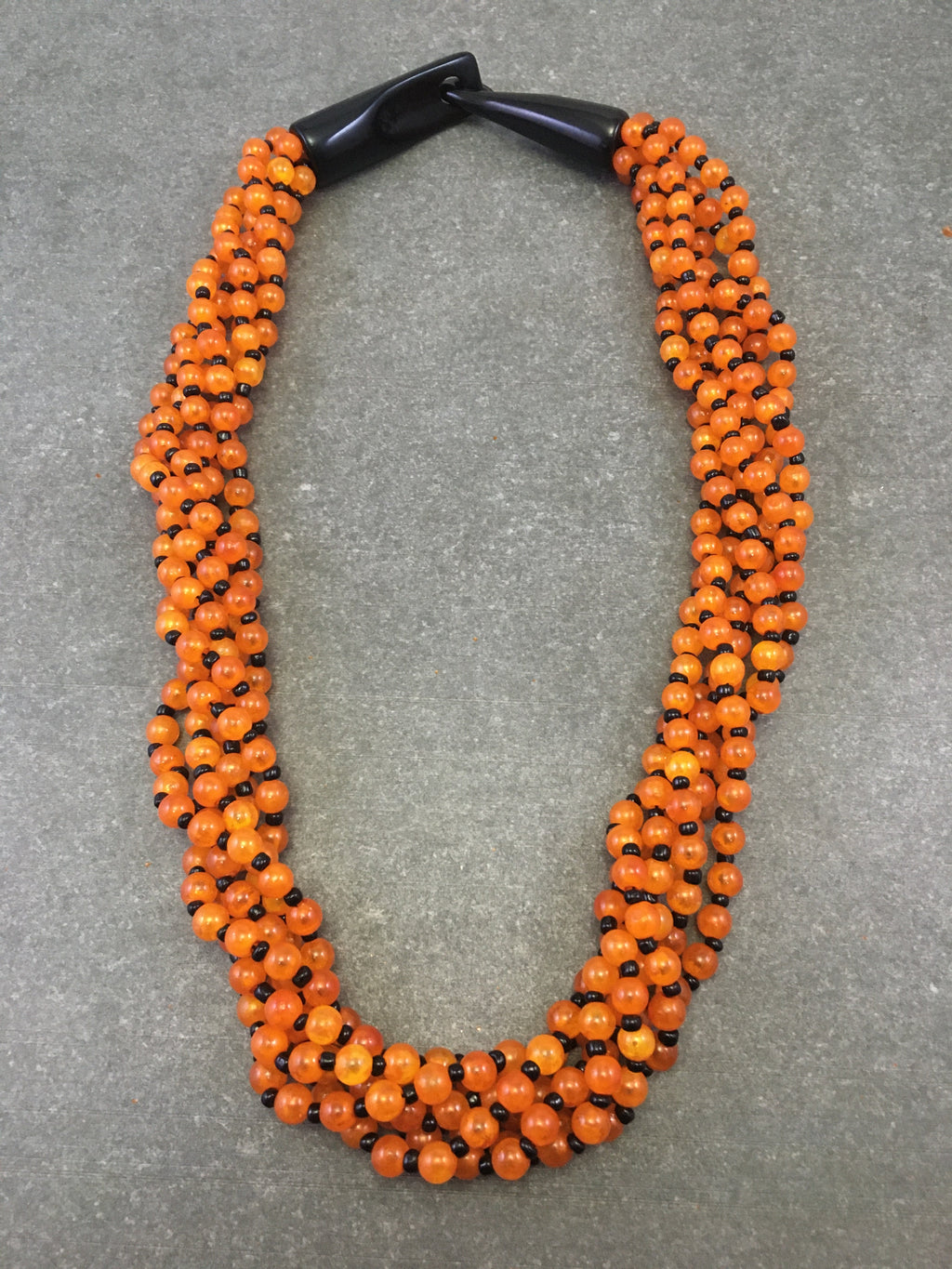 Halskette mit orangefarbenen, schwarzen Harzperlen und Hakenverschluss